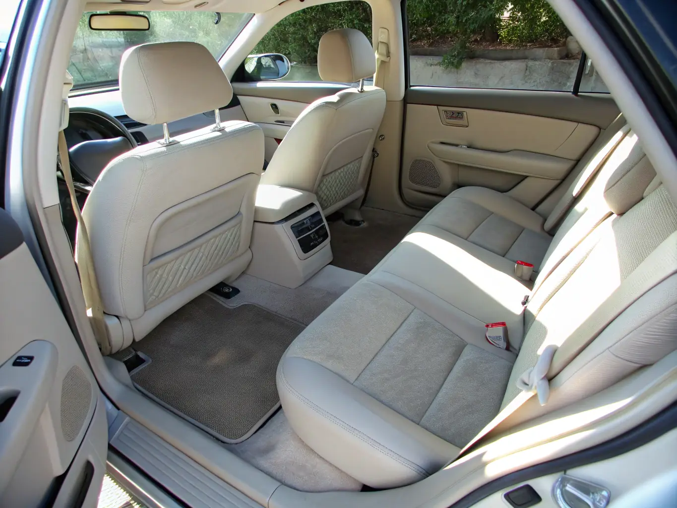 A professional cleaning technician vacuuming a car interior with spotless seats and dashboard, highlighting the cleanliness achieved through interior cleaning.